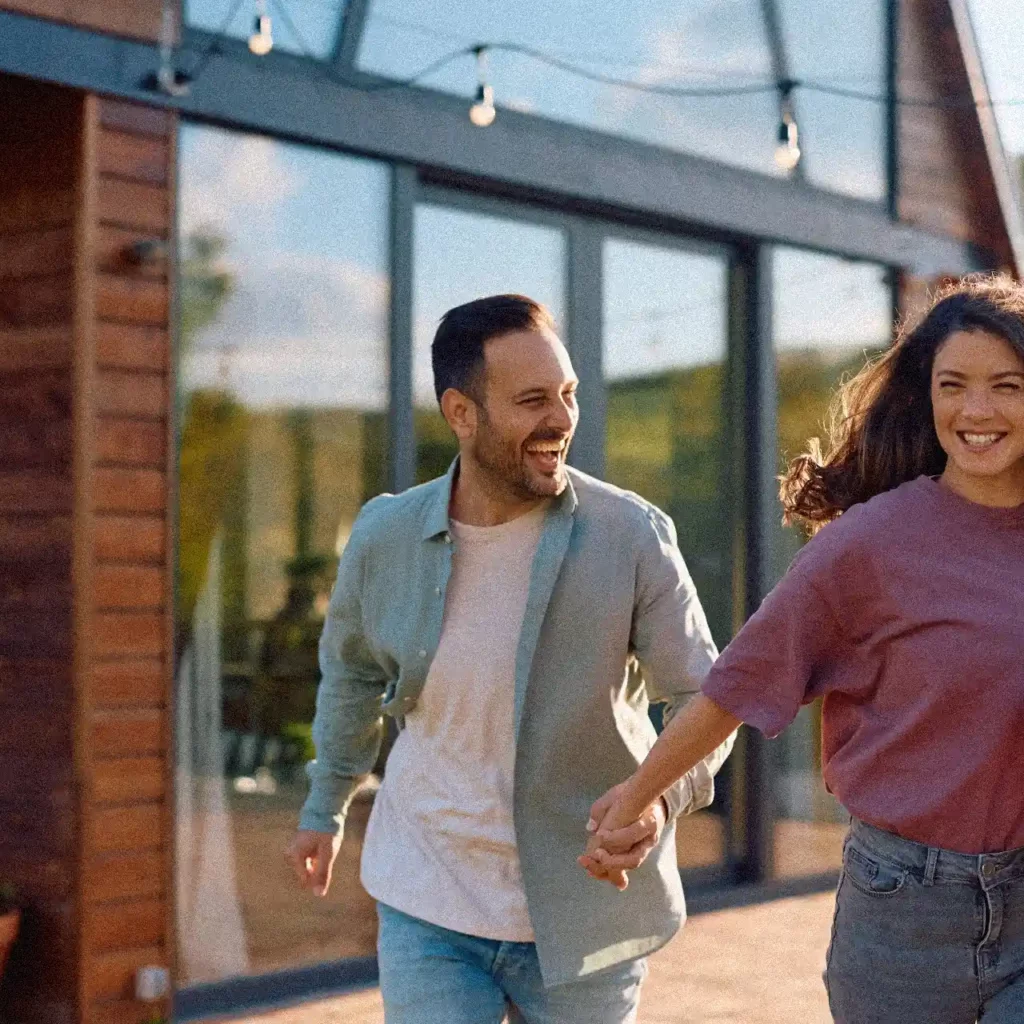 Couple de concubins devant leur maison après un achat immobilier avec apports inégaux