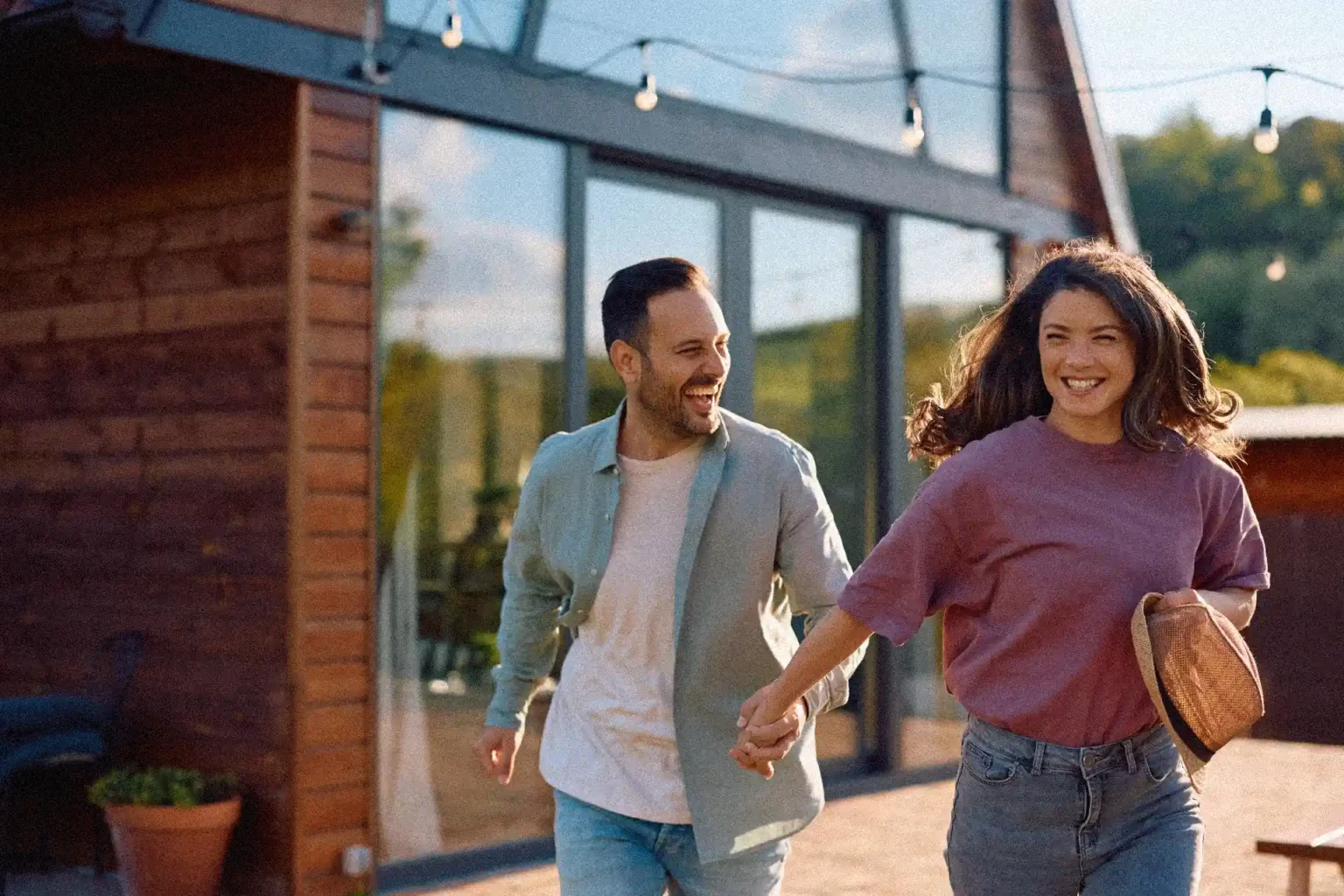 Couple de concubins devant leur maison après un achat immobilier avec apports inégaux